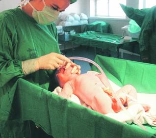 Una matrona atendiendo a un recién nacido en el Hospital San Agustín. 